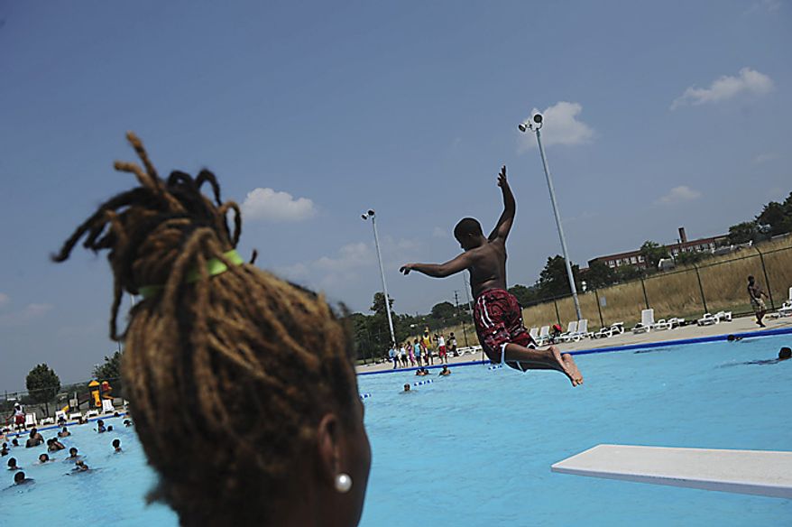 As temperatures reached the high nineties and the heat index went above 100 degrees, lifeguard Breanna Adams,18, watches as kids jump from the diving board into the cool water at the Anacostia Pool and Recreation Center in Washington, D.C., Thursday, July 21, 2011. The kids were not allowed to be identified. (Rod Lamkey Jr/The Washington Times)