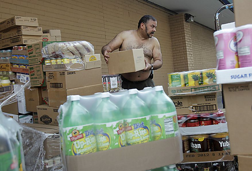 Eddie Ortiz unloads palettes of groceries outside a grocery store in New York, Thursday, July 21, 2011. Because the delivery was four hours late, Ortiz was working through the hottest part of the day. Hot weather that has plagued the Plains for days spread eastward Thursday, blanketing several more states under a sizzling sun and excessive heat warnings that made people sick, shut down summer schools and spurred cities to offer cooling centers and free swimming. (AP Photo/Seth Wenig)