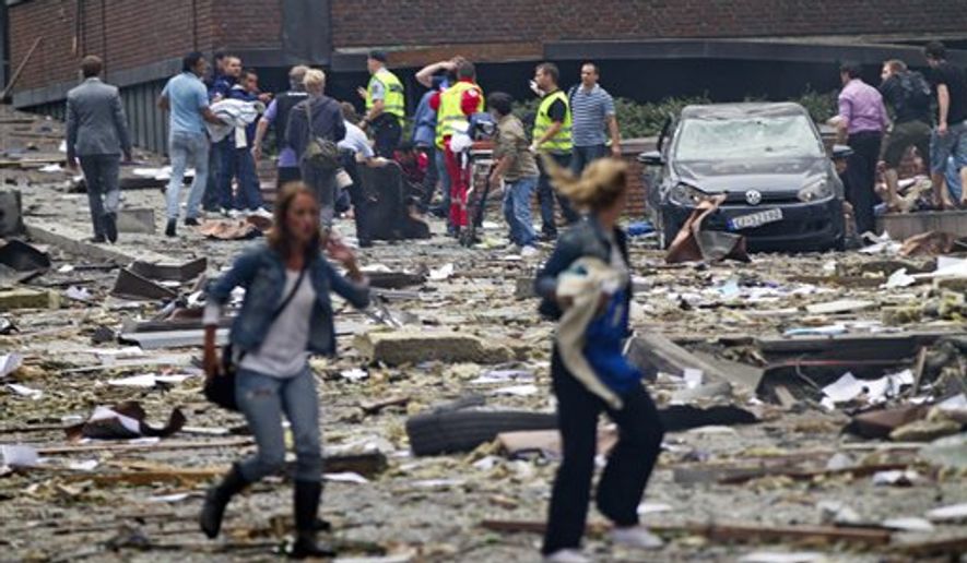 Two women are seen leaving as rescue workers arrive to help the injured following an explosion in Oslo, Norway Friday July 22, 2011. A powerful blast tore open several Oslo buildings including the prime minister's office on Friday. One person was reportedly killed and several were injured, as the blast shattered windows and coated the street with documents. Prime Minister Jens Stoltenberg is safe, government spokeswoman Camilla Ryste told The Associated Press, although it was unclear whether that meant he was uninjured. (AP Photo/Scanpix/Thomas Winje Aijord)
