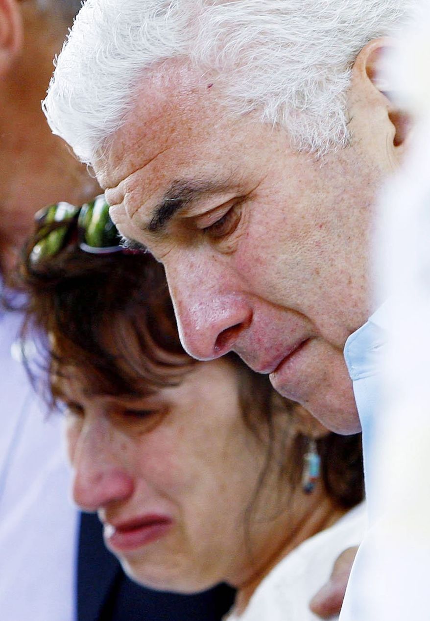 Amy Winehouse's parents Mitch and Janis weep as they view floral tributes outside their daughter's home in London's Camden Square on July 25, 2011. (Associated Press)