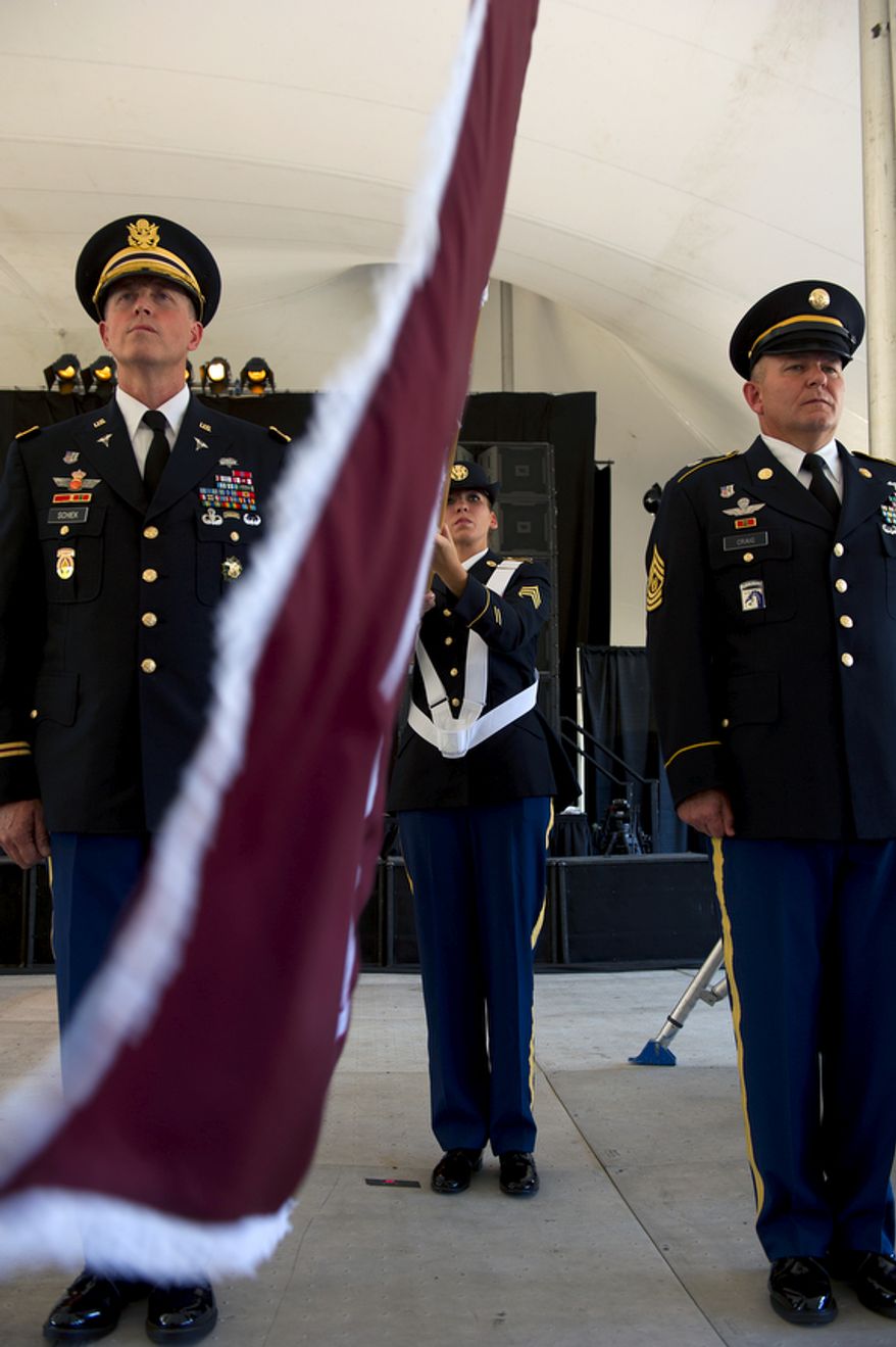 Col. William Schiek, left, and CSM Steven Craig prepare to retire (or "case") the Medical Center Brigade flag, held by SSG Gracie Best, center, during a ceremony Wednesday, July 27, 2011 at Walter Reed Army Medical Center in Washington, D.C. The flags of the various medical units at Walter Reed were all retired during the ceremony as a means of transitioning from the Washington, D.C., facility to Ft. Belvoir and Bethesda Naval Medical Center. (Barbara L. Salisbury/The Washington Times)