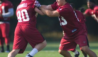 Rookie Ryan Kerrigan (53, right) works through drills during the first day of training camp at Redskins Park in Ashburn, Va., Friday, July 29, 2011. (Rod Lamkey Jr./The Washington Times)