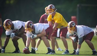 Washington Redskins quarterback John Beck (3) takes the snap while be guarded by Artis Hicks (75) Will Montgomery (63) and Kory Lichtensteiger (78) during the first day of training camp at Redskins Park in Ashburn, Va., Friday, July 29, 2011. (Rod Lamkey Jr./The Washington Times)