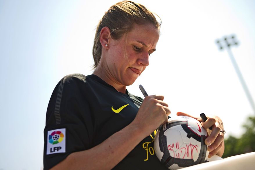 U.S. Soccer player Heather O'Reilly autographs a ball Sunday. Ms. O'Reilly was joined by U.S. teammates Tobin Heath, Ali Krieger and Alex Morgan at a charity soccer match on the Southwest waterfront.