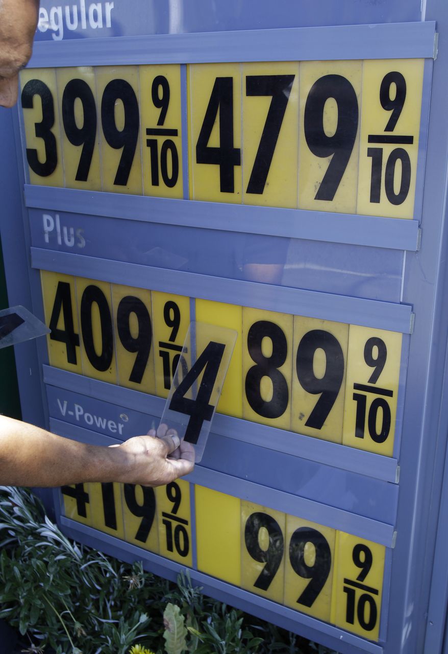 In this June 21, 2011 photo, Shell gas worker Toke Fusi changes gas prices down at a Shell gas station in Menlo Park, Calif. The economy slowed in the first six months of 2011 to its weakest pace since the recession ended. High gas prices and scant income gains forced Americans to sharply pull back on spending. (AP Photo/Paul Sakuma)