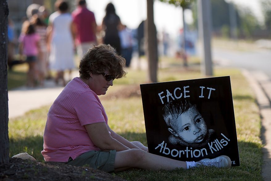 Karen Styer of Germantown, Md. sits with a pro-life sign after a morning ceremony of prayer vigils and rallies against late-term abortion near "late-term abortion provider" Dr. Leroy Carhart's clinic in Germantown, Md. on Tuesday, August 2, 2011. "Until Dr. Carhart came to town, I was on the edge. But when I heard about how late-term abortions are done, I became pro-life," said Styer. The prayers and rallies are a part of the nine-day pro-life protesting event, Summer of Mercy 2.0. (Pratik Shah/The Washington Times)