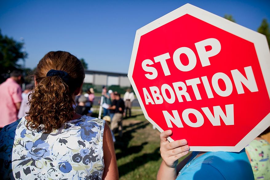 A protester holds a pro-life sign during a morning ceremony of prayer vigils and rallies against late-term abortion near "late-term abortion provider" Dr. LeRoy Carhart's clinic in Germantown, Md. on Tuesday, August 2, 2011. The prayers and rallies are a part of the nine-day pro-life protesting event, Summer of Mercy 2.0. (Pratik Shah/The Washington Times)