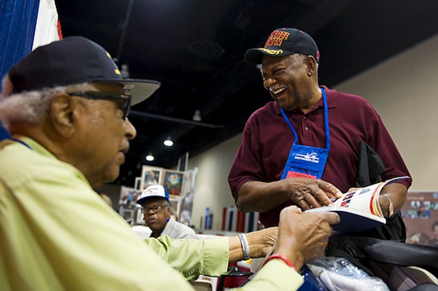 From left, original members of the Tuskegee Airmen George W. Porter, from Sacramento, Calif., and Harry Quinton, from Williamsburg, Va., share a laugh as they look through a commemorative journal of Tuskegee Airman history, on the first day of the 40th Annual Tuskegee Airmen National Convention, at the Gaylord Hotel and Convention Center, in National Harbor, Md., Wednesday, Aug. 3, 2011. Both Porter and Quinton served as mechanics and flight engineers in the Tuskegee Airmen. "It's wonderful to come back and see everyone," said Porter. "We didn't even realize we were stationed at the same base together until we met here." The two were both stationed at Godman Field near Fort Knox in Louisville, Ky. (Drew Angerer/The Washington Times)