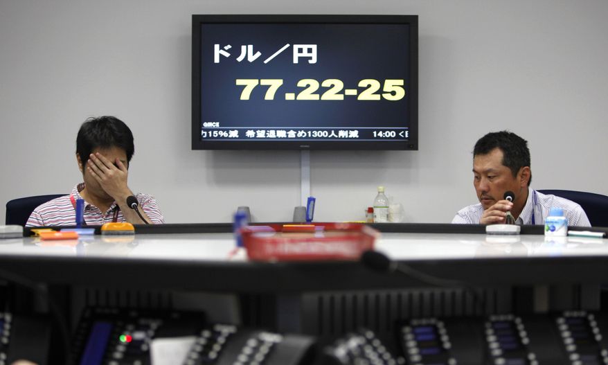 Money traders work Aug. 3, 2011, in front of the electric board showing the yen-dollar exchange rate at a money market brokerage firm in Tokyo.