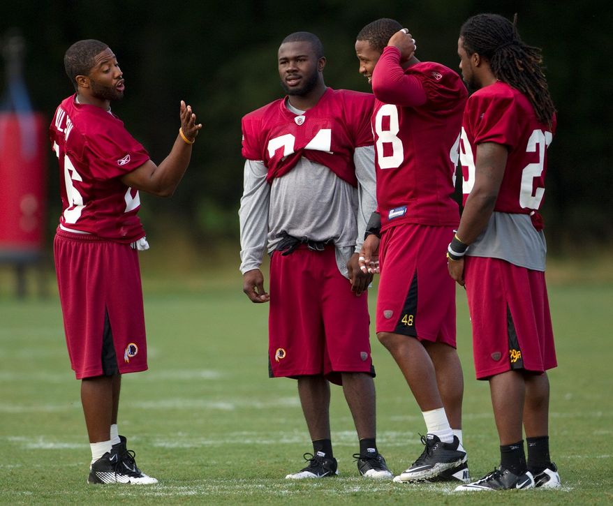 Cornerback Josh Wilson, who signed as a free agent from Baltimore, chats with Byron Westbrook (second from left), Chris Horton (second from right), and Reggie Jones (right) during practice Friday. (Associated Press)