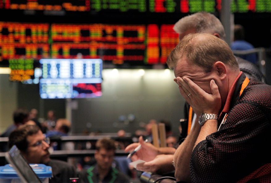 Trader Andrew Stavros reacts on the floor of the CME Group on Monday in Chicago after the close of trading in the NASDAQ-100 Index pit. Stocks plummeted after anxiety overtook investors on the first trading day since S&P downgraded U.S. debt. (Associated Press)