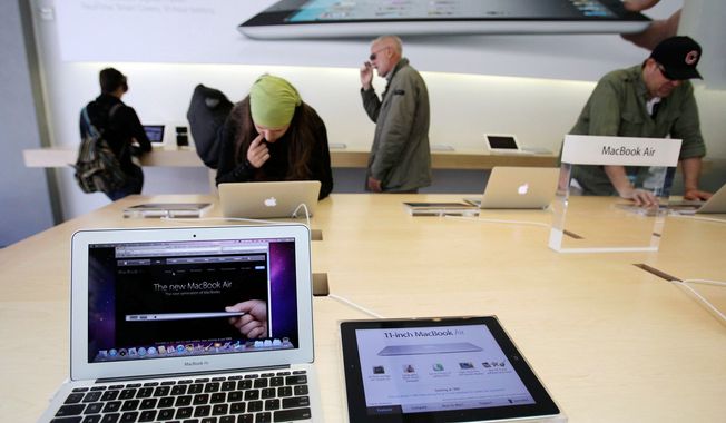 ** FILE ** Apple customers look at the Apple MacBook Air in San Francisco. (Associated Press)