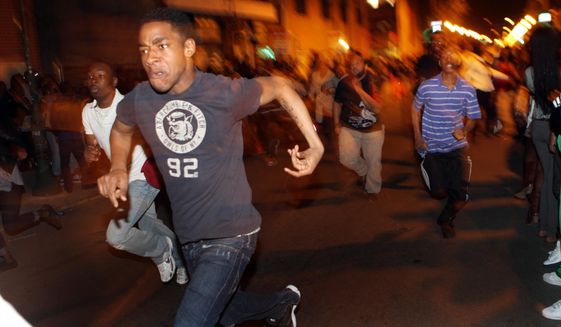 **FILE** In this photo from March 20, 2010, young people run down South Street in Philadelphia during a flash mob incident that involved thousands. (Associated Press/The Philadelphia Inquirer)