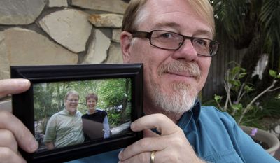 John Olsen shows a picture himself with his biological mother Pat Holmes at his home in Orange, Calif., on Monday, Aug. 8, 2011. Olsen, who was adopted at birth, attributes his brainpower to his genes. In his late 20s, Olsen took a genius test and scored high enough to get accepted into Mensa, the high IQ group. (AP Photo/Nick Ut)