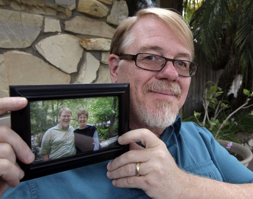 John Olsen shows a picture himself with his biological mother Pat Holmes at his home in Orange, Calif., on Monday, Aug. 8, 2011. Olsen, who was adopted at birth, attributes his brainpower to his genes. In his late 20s, Olsen took a genius test and scored high enough to get accepted into Mensa, the high IQ group. (AP Photo/Nick Ut)
