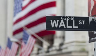 A Wall Street sign hangs near the New York Stock Exchange in New York. (AP Photo/Jin Lee)