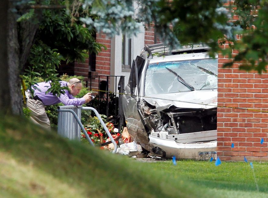 ASSOCIATED PRESS
A law enforcement official photographs an SUV that suddenly accelerated out of control and struck and killed three walking-club members waiting on a sidewalk for friends in Voorheesville, N.Y., on Wednesday.