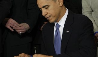 ** FILE ** President Obama signs the health care bill at the White House in Washington on March 23, 2010. (Associated Press)