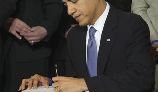 President Obama signs the health care bill in the White House on March 23, 2010. (Associated Press) **FILE** 