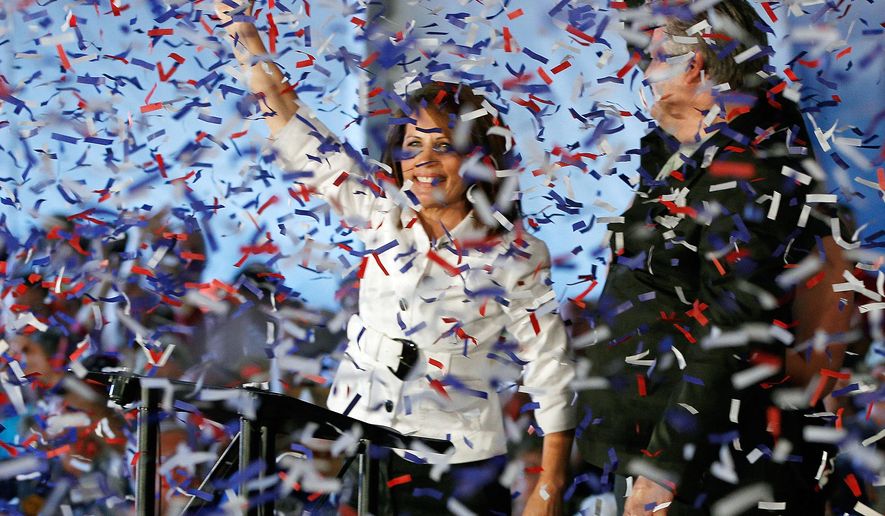 Confetti falls as Rep. Michele Bachmann, Minnesota Republican, and her husband, Marcus, rally supporters at the Iowa Republican Party&#39;s Straw Poll in Ames, Iowa, on Saturday, Aug. 13, 2011. (AP Photo/Charles Dharapak)
