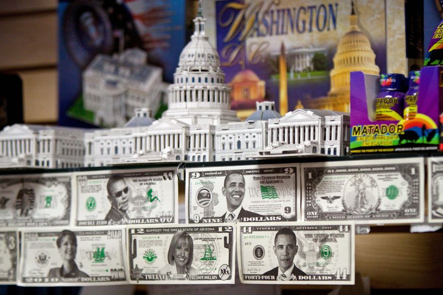 PHOTOGRAPHS BY PRATIK SHAH/THE WASHINGTON TIMES
Who's that cool-looking dude in the sunglasses (top)? Political novelty money is displayed at Souvenir World in Northwest. The souvenir cash includes a bill of President Obama with sunglasses and one picturing former Alaska Gov. Sarah Palin. The store also sells shirts with "anti" messages (left).