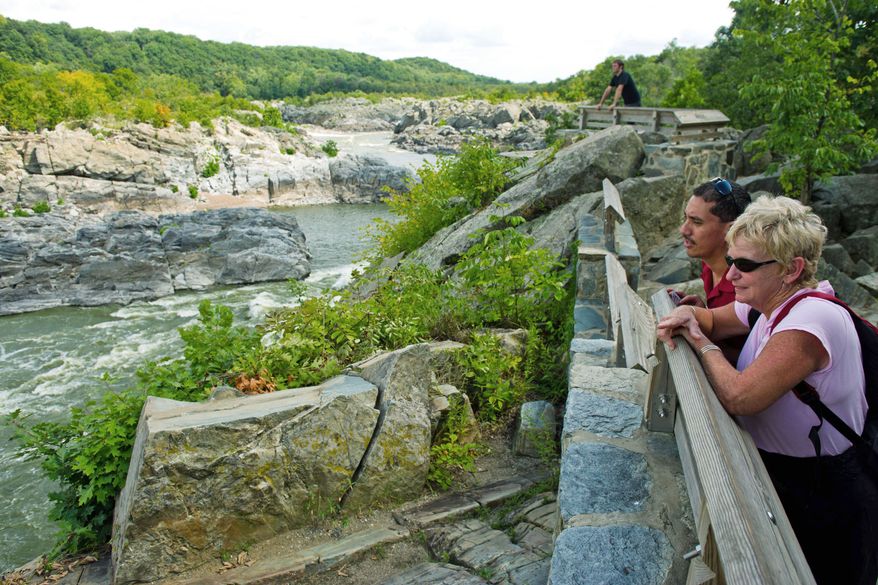 Antonio Rodriguez and Rutha Pryputniewicz, visiting from Wyoming, take in the view of the Potomac River from Great Falls National Park in McLean on Monday. (Drew Angerer/The Washington Times)