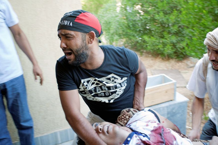 ASSOCIATED PRESS PHOTOGRAPHS
A Libyan rebel reacts while helping to evacuate a wounded man after a shelling attack that struck mostly civilians in Zawiyah on Monday.