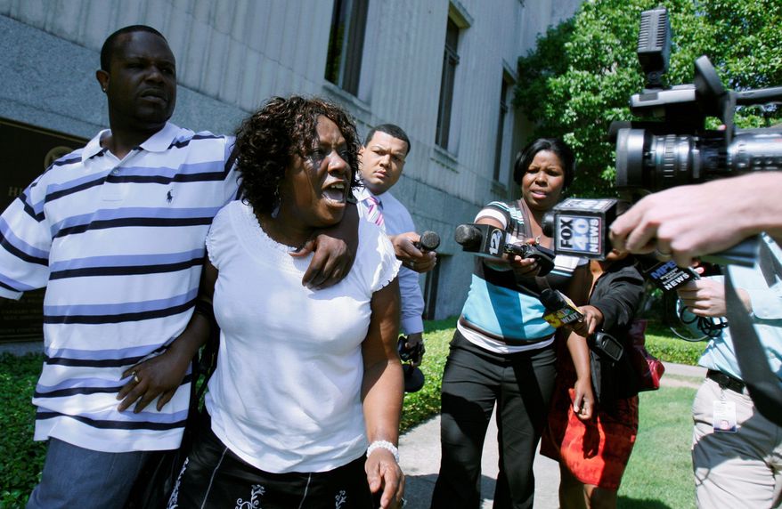 Associated Press photographs
Ablene Cooper and son Antonio Cooper leave the Hinds County courtroom in Jackson, Miss., on Tuesday, after a circuit judge dismissed her lawsuit against the author of the novel "The Help." Ms. Cooper claims a main character, Aibileen, is based on her.
