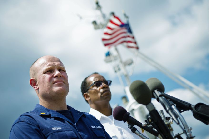 Coast Guard Lt. Cmdr. Randall Brown (left) and D.C. Fire Chief Kenneth Ellerbe discuss a black sheen seen on the Anacostia River Monday and Tuesday. First water samples tested positive for petroleum. (Drew Angerer/The Washington Times)