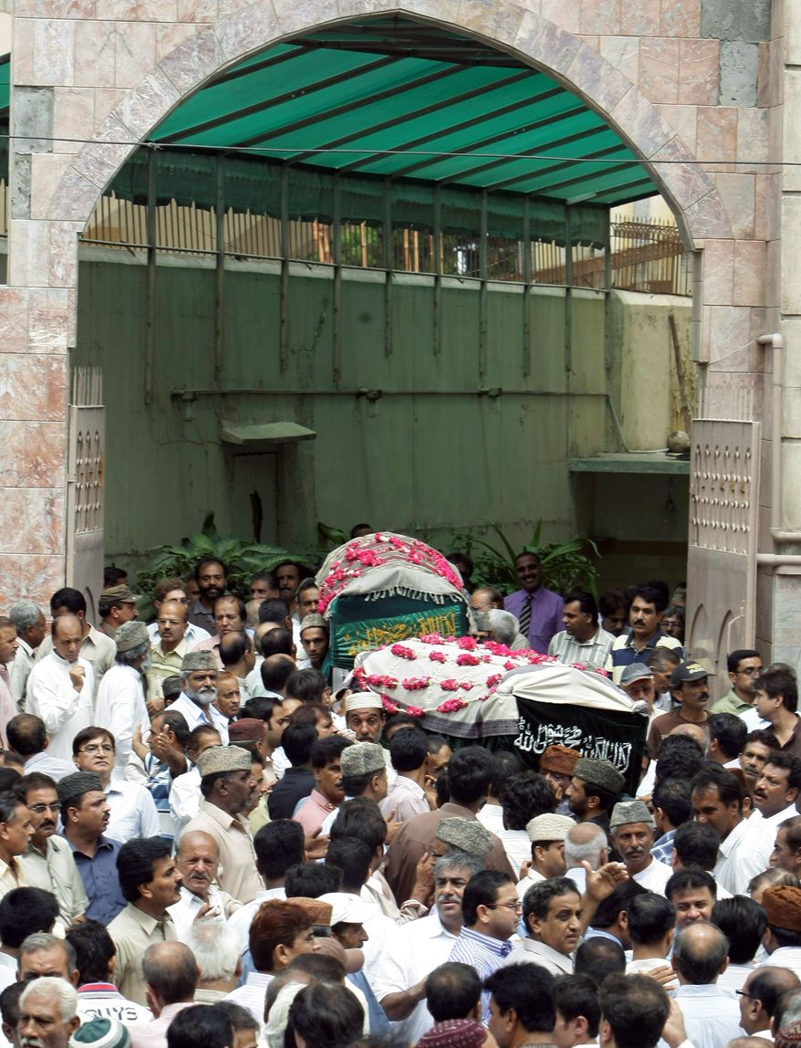 Mourners carry the bodies of a former lawmaker of the ruling Waja Karim Dad party and his friend at their funeral in Karachi on Thursday. They were fatally shot in violence carried out by gang members. (Associated Press)