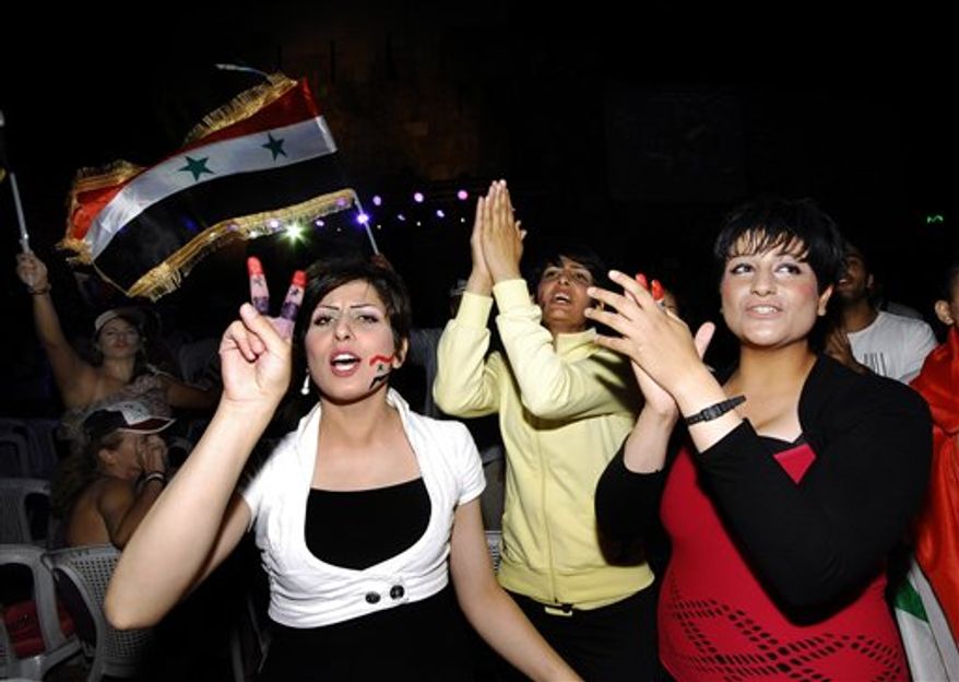 Supporters of Syrian President Bashar Assad shout slogans and wave their national flag, as they protest to show their solidarity to their president, in Damascus, Syria, on Friday Aug. 19, 2011. Assad, who inherited power from his father in 2000, is facing the most serious international isolation of his rule. On Thursday, the United States and its European allies demanded he step down. Syrian security forces killed at least 20 protesters Friday despite promises by President Bashar Assad that the military operations against the 5-month-old uprising are over. (AP Photo/Muzaffar Salman)