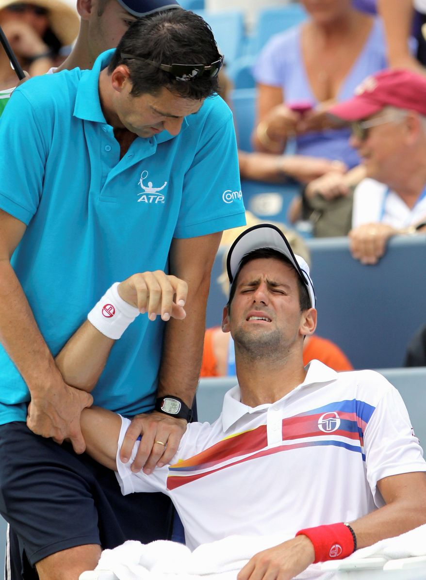 ASSOCIATED PRESS
Novak Djokovic, the top-ranked player in the world, has his shoulder worked on before retiring in the Western & Southern Open.