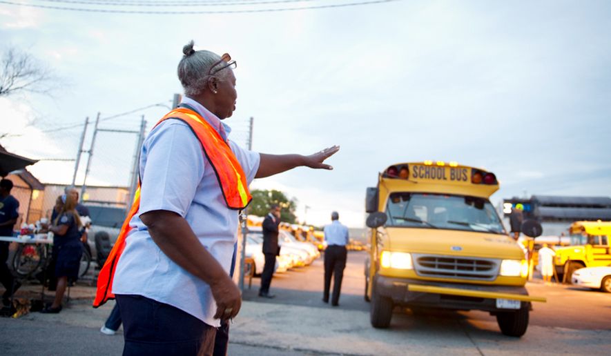 Ivory Darell directs school buses on the first day of school in Washington, DC. (Rod Lamkey Jr./The Washington Times) **FILE**