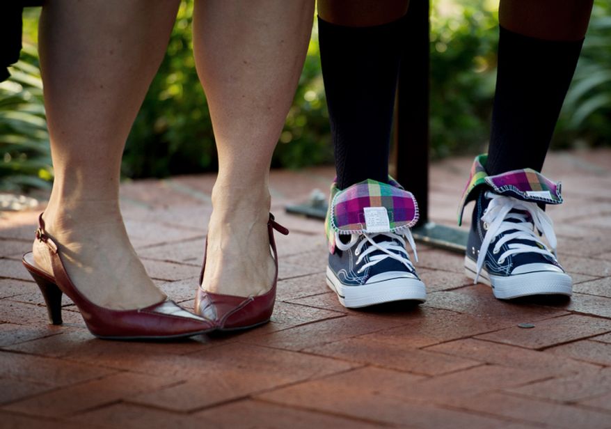 John Tyler Elementary School Principal Jennifer Frentress and the feet of student Ty-Tiana Corbin arriving for the first day of school. (Rod Lamkey Jr./The Washington Times)