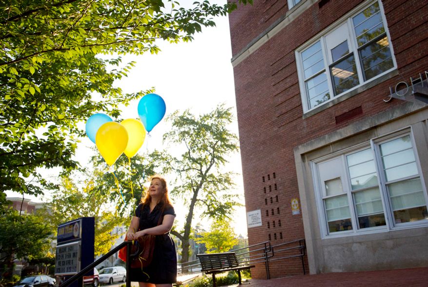 John Tyler Elementary School Arts Integration Coordinator Lauren Eskovitz arranges balloons out front in preparation for the arrival of students for the first day of school at John Tyler Elementary School. (Rod Lamkey Jr./The Washington Times)