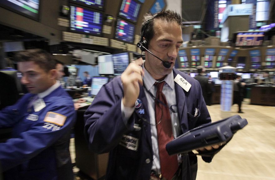 Trader Gregory Rowe (right) works on the floor of the New York Stock Exchange on Aug. 22, 2011. (Associated Press)