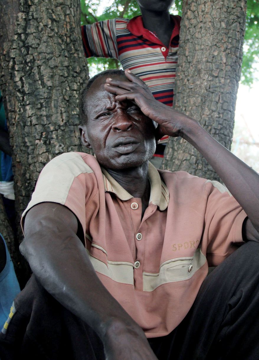 In this Wednesday, July 13, 2011 photo, wearing a filthy polo shirt, ratty sandals made from old tires, and a distant, pained expression, Nyati Kelabo sits in the muddy black dirt under a tree where he said he had been sleeping since arriving in Pibor after escaping the raiding in his village, a day's walk from Pibor, South Sudan. (AP Photo/Maggie Fick)