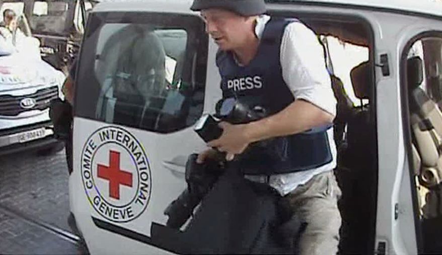 A journalist arrives at the Corinthia hotel after being evacuated from the Rixos Hotel in Tripoli in this image taken from television on Aug. 24, 2011. (Associated Press/APTN)