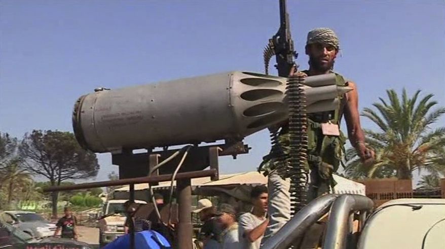 In this image made from television, rebel fighter stands on the back of a truck with an rocket launcher in Moammar Gadhafi's Bab al-Aziziya fortress-like compound in Tripoli, Wednesday, Aug. 24, 2011. (AP Photo/APTN)