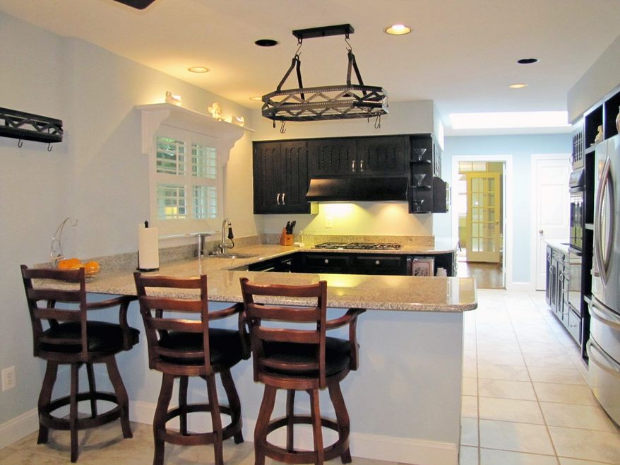 The home's kitchen was remodeled in 2010 and features black-painted wood cabinets and granite counters.