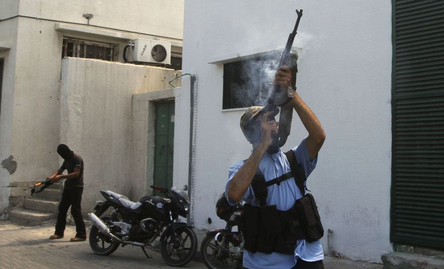 Masked Palestinian militants fire their rifles on Aug. 25, 2011, in Gaza City during the funeral of Islamic Jihad militant Ateya Mkat, 22, who was killed the day before in an Israeli air strike. (Associated Press)