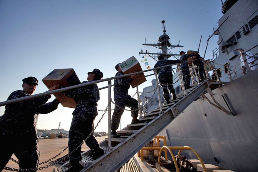 Crew members of the guided missile destroyer Mason load food supplies aboard the ship early Thursday morning as the ship prepared to get underway ahead of approaching hurricane Irene. The U.S. Navy ordered more than 60 ships out to safer waters so they could better weather the storm. (AP Photo/TheVirginian-Pilot, Bill Tiernan)