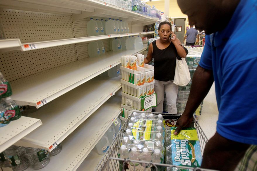 Shoppers stock up on water from rapidly emptying shelves at a grocery store in Far Rockaway in New York. Mayor Michael Bloomberg urged New York City residents living in low-lying areas to line up a place to stay on high ground ahead of a possible evacuation this weekend due to Hurricane Irene. (AP Photo/Seth Wenig)