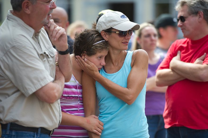 Alexandria resident Kelly DeMaso (right) waits with her daughter Julianna, 11, as they and others wait in line for sand bags from a city maintenance truck at the corner of King and N. Lee Streets in Old Town Alexandria, Va, Friday, August 26, 2011. In a city which saw severe flooding during Hurricane Isabel in 2002, business owners and residents are wasting no time preparing for Hurricane Irene. (Rod Lamkey Jr./The Washington Times)