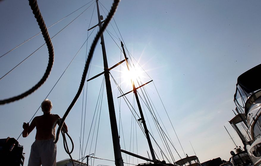 Jason Lacey throws a rope to add another line for his boat "Transit" at Anchorage Marina before the arrival of Hurricane Irene, Friday, Aug. 26, 2011, in Baltimore. (AP Photo/Alex Brandon)