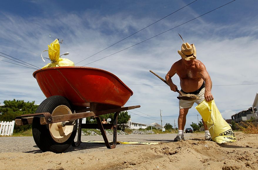 Sandbridge resident Sonny Latulipe fills sandbags in preparation for the arrival of Hurricane Irene in Virginia Beach, Va., Friday, Aug. 26, 2011. Hurricane Irene is expected to hit the area Saturday. (AP Photo/Steve Helber)