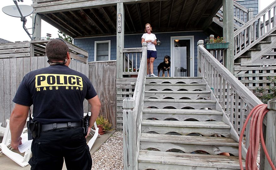 Nags Head police officer Edward Mann speaks with resident Debbie Hickey about Hurricane Irene as it approaches the Outer Banks in Nags Head, N.C., Friday, Aug. 26, 2011. Mann was warning residents who have not evacuated that assistance will be limited after the storm winds reach 60 miles per hour. (AP Photo/Gerry Broome)