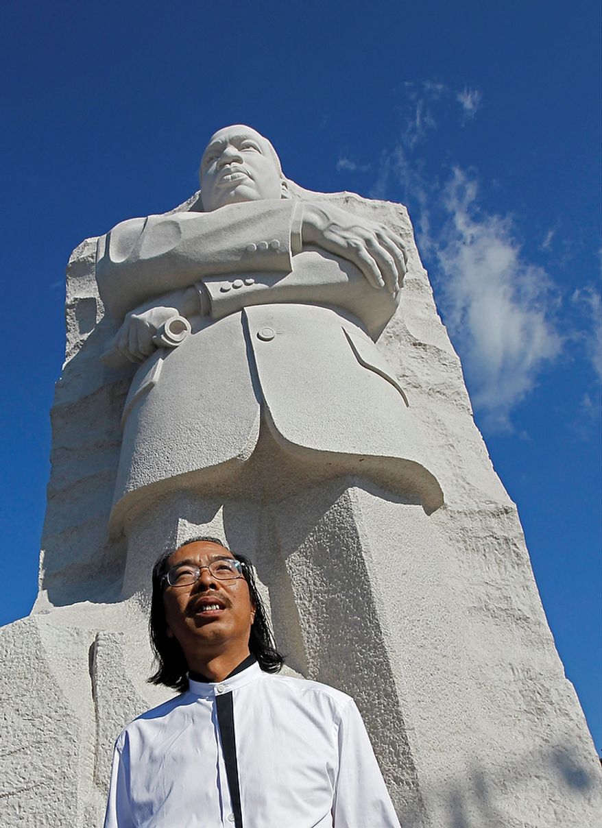 Sculptor Lei Yixin, from China, poses in front of the Martin Luther King, Jr. Memorial ahead of its dedication this weekend in Washington, Monday, Aug. 22, 2011. (AP Photo/Charles Dharapak)