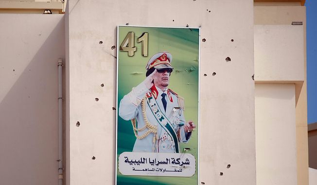 A portrait of Moammar Gadhafi on a wall covers by bullets marks is displayed on a building in the Abu Salim district, in Tripoli, Libya, Friday, Aug. 26, 2011, where rebels had battled Gadhafi&#x27;s fighters holed up in residential buildings for most of the previous day. (AP Photo/Francois Mori)