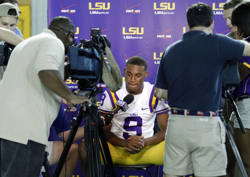 This Aug. 9, 2011 file photo shows LSU quarterback Jordan Jefferson talking to reporters during NCAA college football media day in Baton Rouge, La. Police have issued arrest warrants charging LSU quarterback Jordan Jefferson and a teammate, Joshua Johns, with second-degree battery for a bar fight that injured four people last week. Baton Rouge police Sgt. Don Stone said in a statement Friday, Aug. 26, 2011, that investigators have contacted the players' attorney, Nathan Fisher, and LSU coach Les Miles, and asked for the players to turn themselves in. (AP Photo/Gerald Herbert, File)